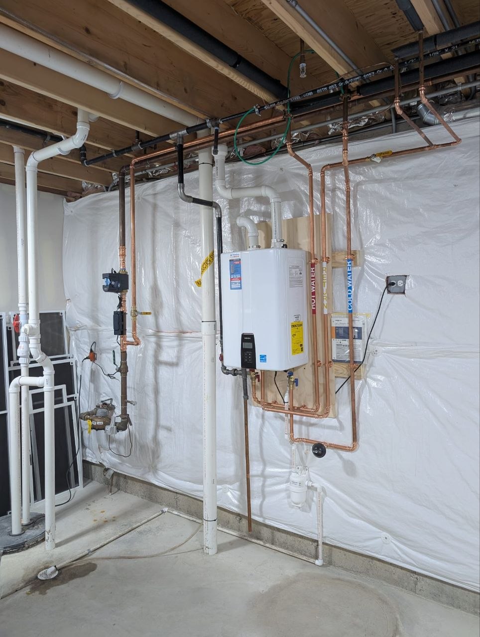 New plumbing rough-in with PEX manifold and copper lines during new home construction